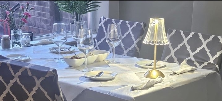 A warmly lit table set for dinner at Café 118